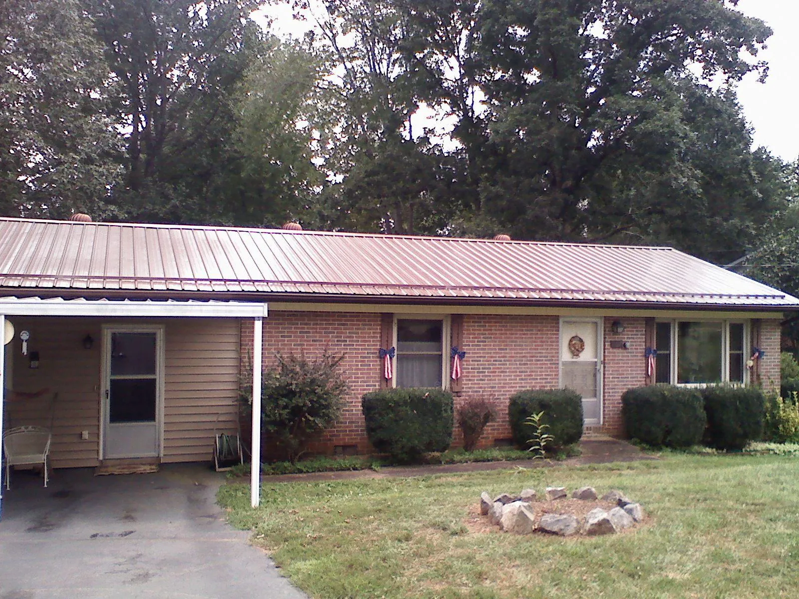 Bronze metal roof and carport on a brick ranch home — Roof Repair work by our crew in Archer